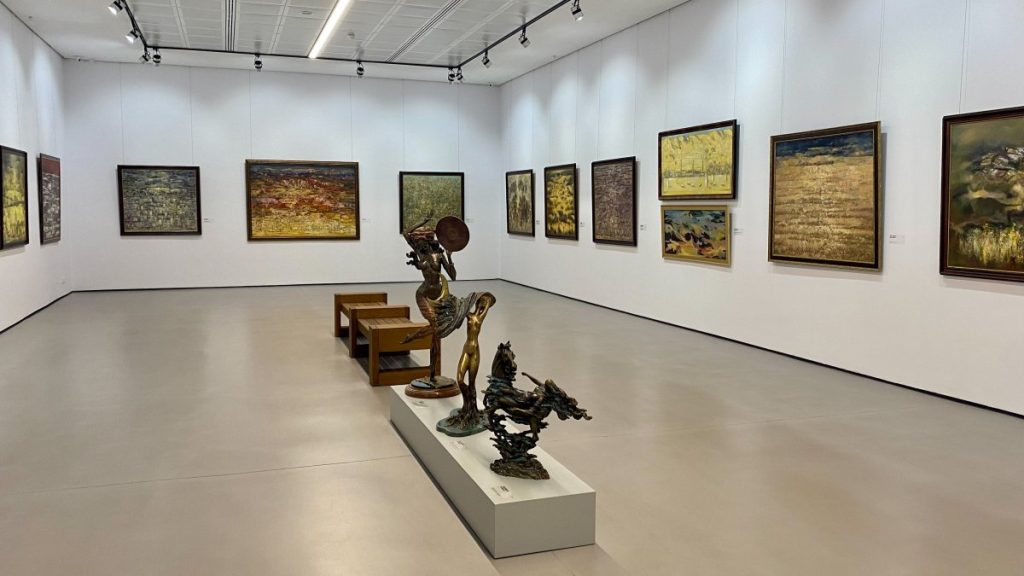 A room filled with paintings and sculptures.