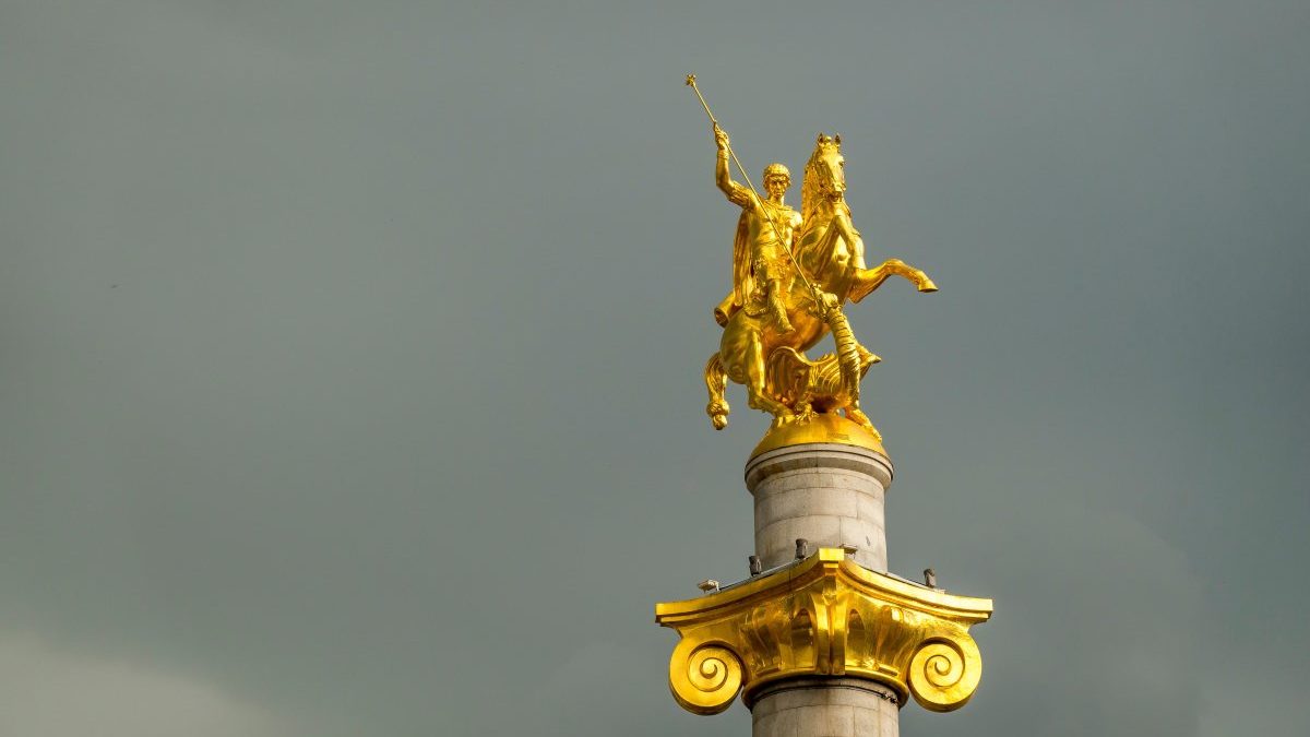 A golden statue of a horse on top of a column.