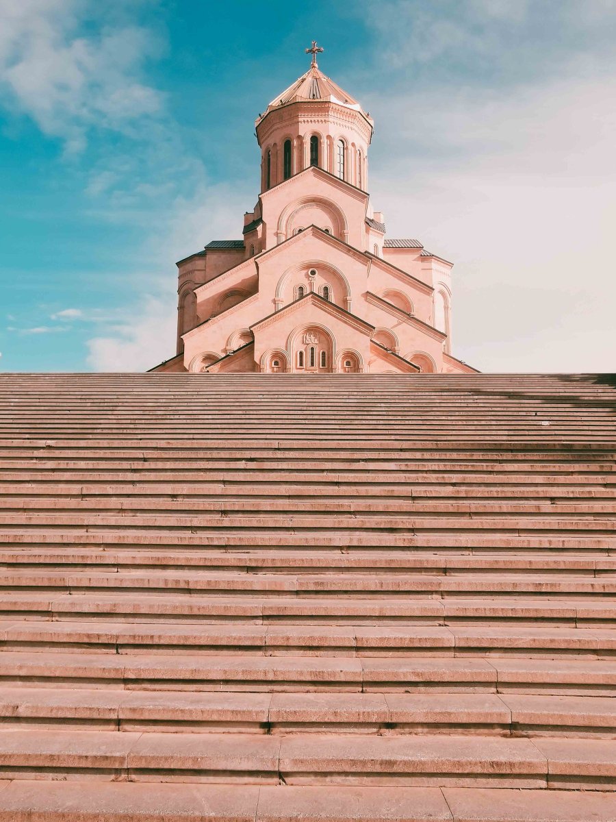 A pink church with steps leading up to it.