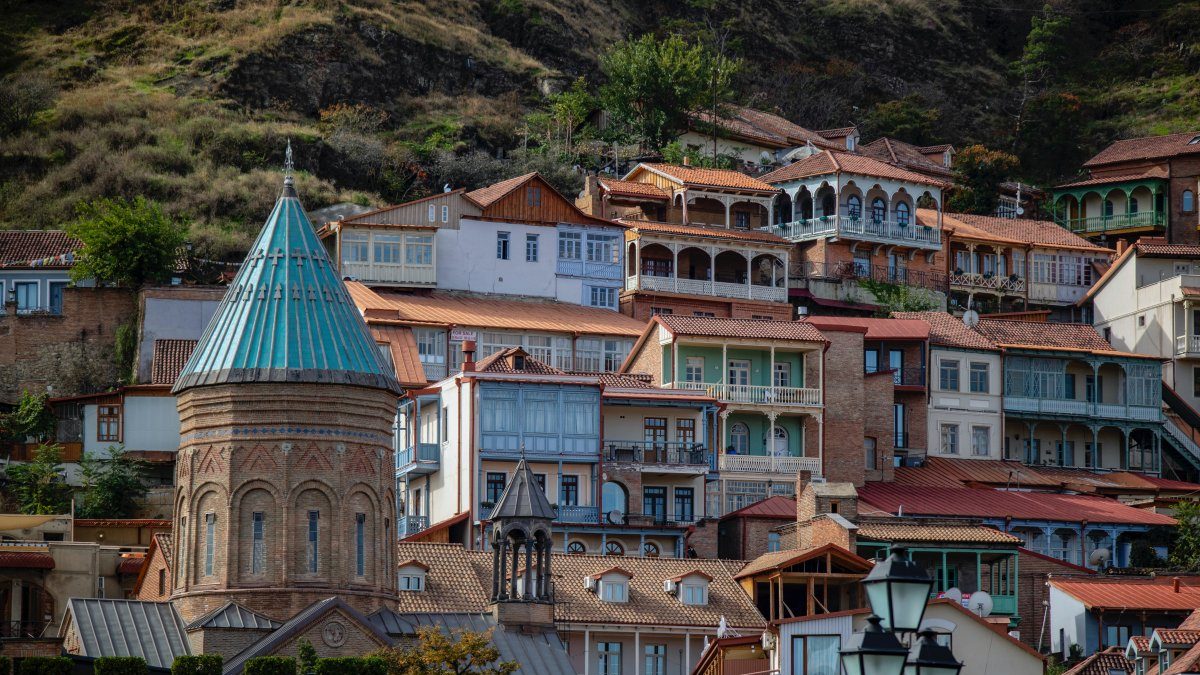 The old city of Tbilisi with a lot of houses on top of a hill.