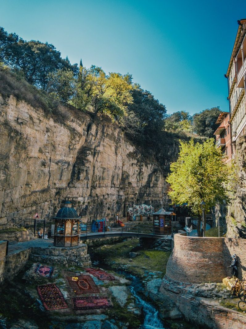 A river runs through the canyon near a cliff in Tbilisi