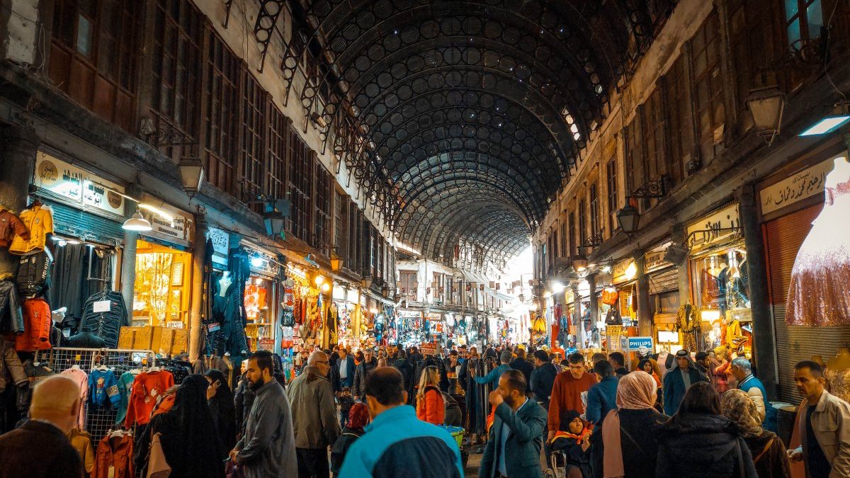 The crowded Al-Hamidiyeh Souk in Damascus, Syria with many people walking through it.