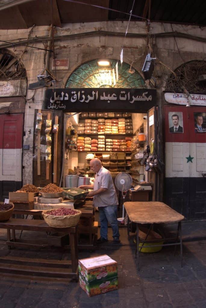 A Syrian Local shop owner selling spices inside a souk