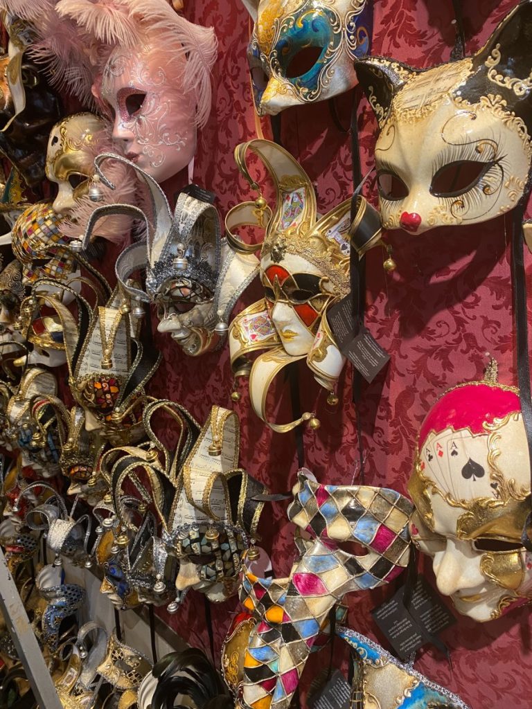 A display of authentic venetian masks on a wall.