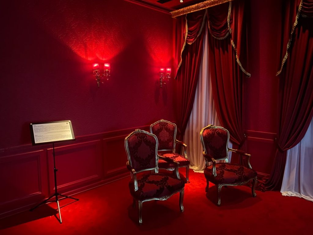 A red room in the museum that is luxuriously decorated
