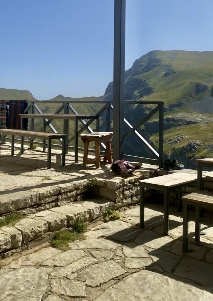 The Astraka refuge courtyard with a table and a chair, used for travelers to rest