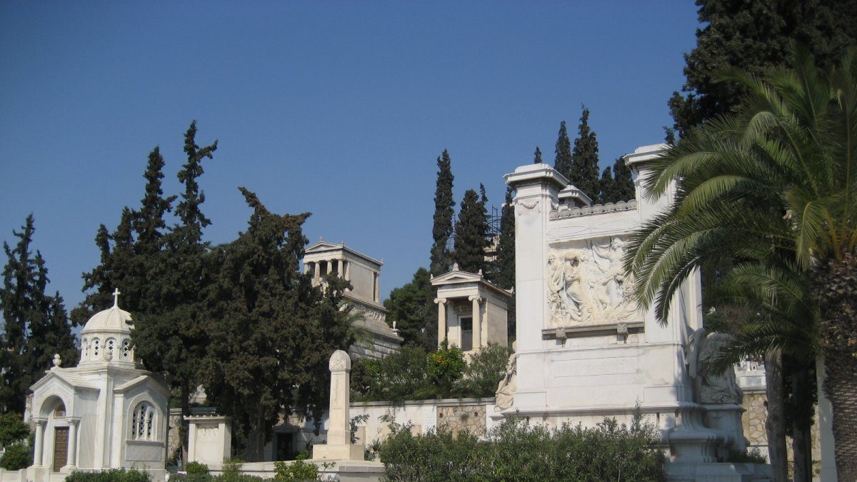 White marble statues and classical buildings in the first cemetery of athens