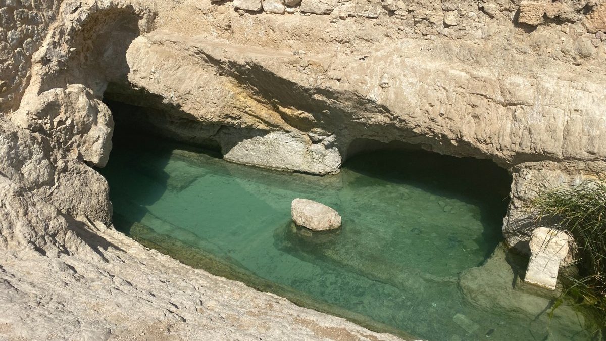 A cave with a pool of water in it