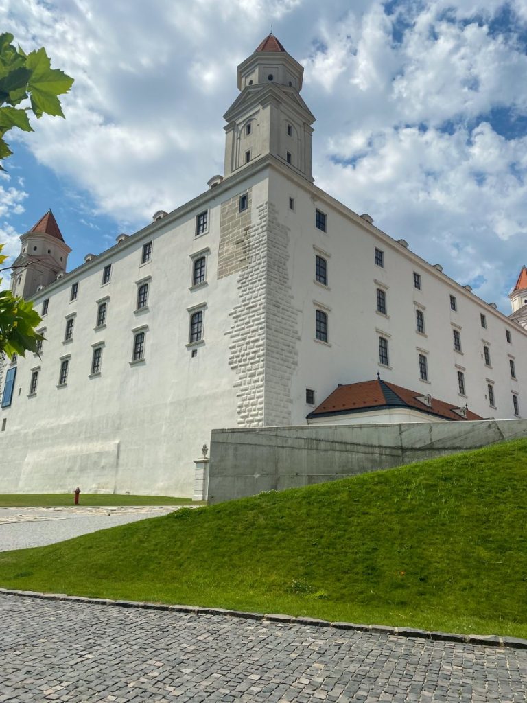The white Bratislava Castle with its large archway, perfect for visitors exploring Bratislava from Vienna.