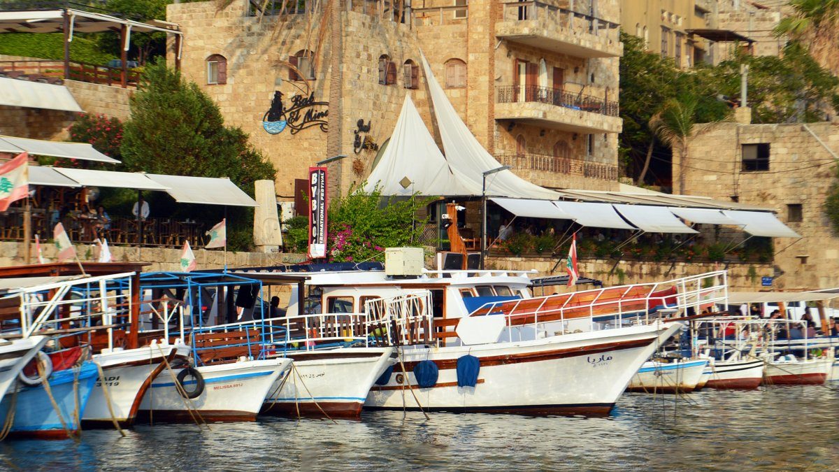 A group of boats docked in the water, perfect for those seeking the best travel guide for Beirut to explore its scenic waterfront.