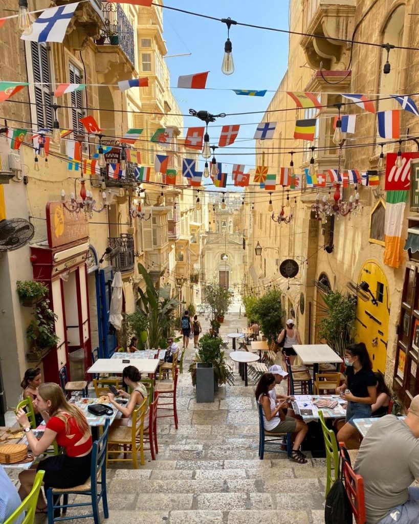 A beautiful setting with flags in a street full of restaurants in Valetta, Malta