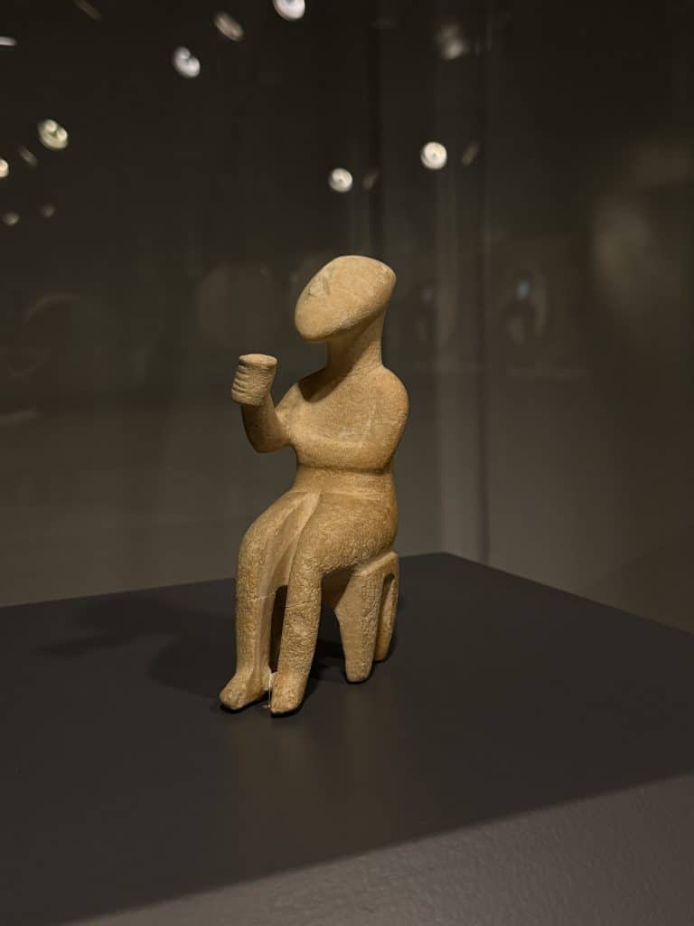 An idol, a little statue depicting a person sitting in a chair and drinking something. It is displayed in the museum of Cycladic art, one of my favourite museums in Athens