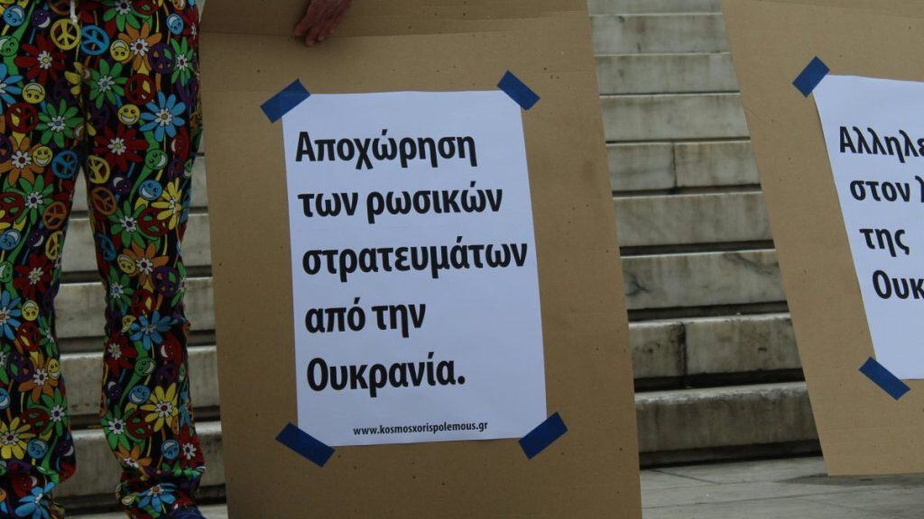 Demonstrators hold signs demanding the withdrawal of Russian troops from Ukraine.