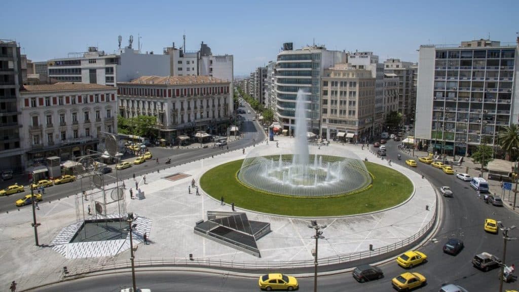 Omonoia square with a large fountain and surrounding buildings in a vibrant urban setting.