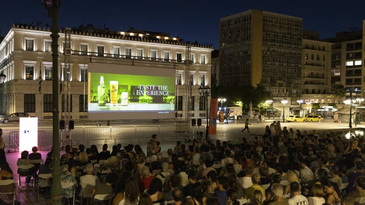People watching a movie in a square during a summer night as part of the Athens Open Air Film Festival.